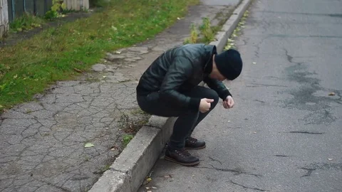 The man sat down on the curb to rest Vidéo 82117929