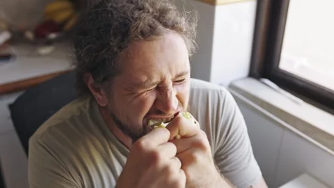 Man savoring every bite of a sour green apple Stock Footage 319749713