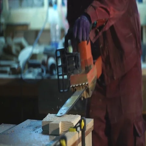 The man with the saw makes a pattern on a wooden Board Stock Footage 69488572