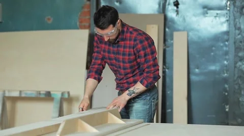 Man sawing a board in a carpentry workshop using a circular saw Video stock 61364234