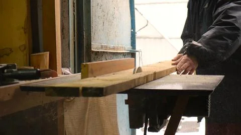 Man sawing board on circular table in workshop Stock Photos