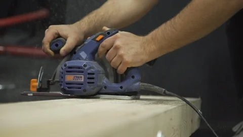 Man sawing board with an electric saw Stock Footage