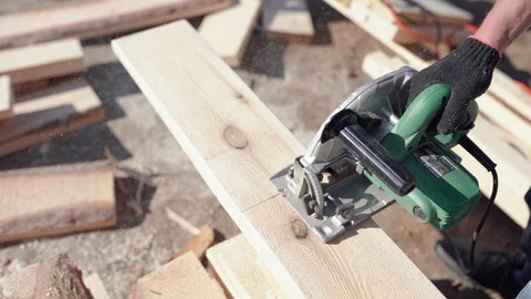 A man is sawing a board. Work with a tree. Saw boards. Build a house. Hand Stock Footage 130047124