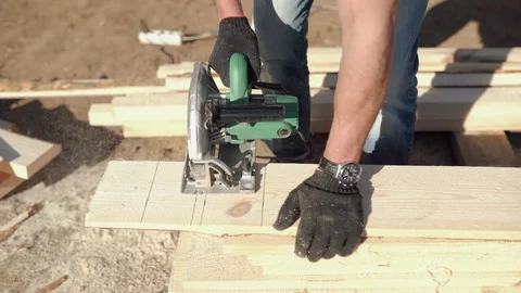 A man is sawing a board. Work with a tree. Saw boards. Build a house. Hand Stock Footage 130050010