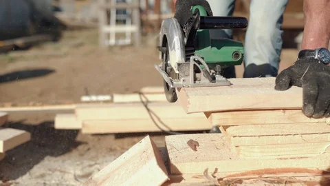 A man is sawing a board. Work with a tree. Saw boards. Build a house. Hand Stock Footage 130051044