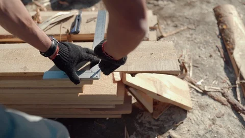 A man is sawing a board. Work with a tree. Saw boards. Build a house. Hand Stock Footage 130051397