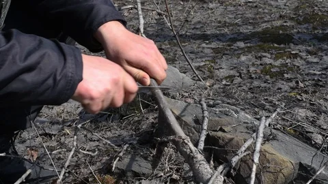 Man sawing a branch with a folding knife in the spring outdoors Stock Footage 111144962