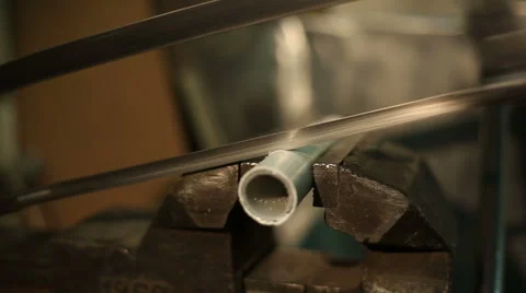 Man sawing with a manual hacksaw the pipe, gripped in a vise Stock Footage 59596084