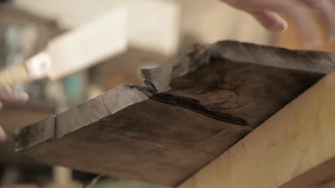 A man sawing an old walnut board with a hand saw Stock Footage 137149988