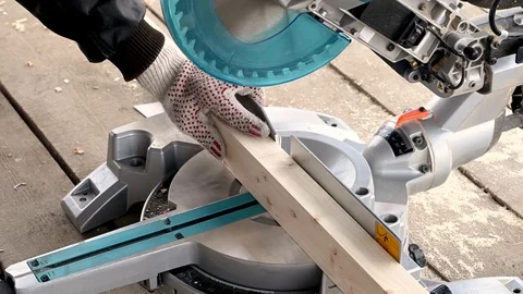 Man sawing wood using a miter saw Stock Footage 119369727