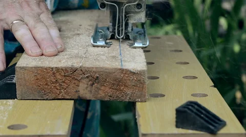 Man sawn a wooden board with an electric jigsaw. Stock Footage