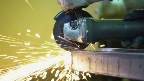 The man saws angular grinding machine iron details. Sparks from angular grinding Stock Footage 81556513