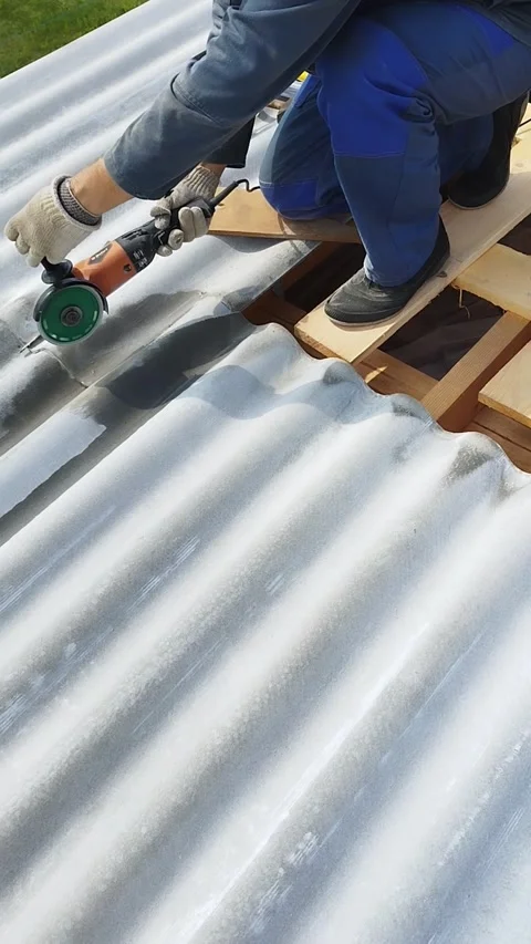 A man saws a corner in the sheets for a tight adhesion of slate sheets Stock Footage 311393762