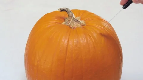 Man Saws the Lid of a Pumpkin in 4k Stock Footage 68757616
