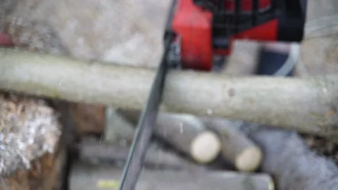 A man saws a log with an chain saw. Process of sawing wood with an chain saw Stock Footage 162938925