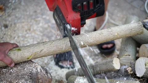A man saws a log with an chain saw. Process of sawing wood with an chain saw Stock Footage 163192953