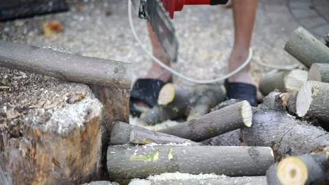 A man saws a log with an chain saw. Process of sawing wood with an chain saw Stock Footage 163326039