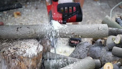 A man saws a log with an chain saw. Process of sawing wood with an chain saw Stock Footage 163404280