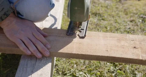 Man saws rough board with electric jigsaw Stock Footage 150550459