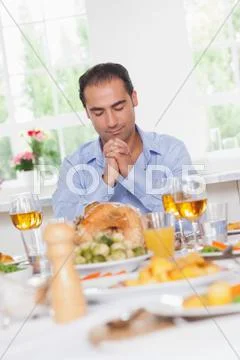 Man saying grace before dinner Stock Photos