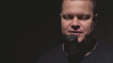 A man says something into a microphone Stock Footage 183456895