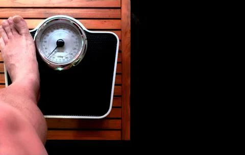 Man on the scale in the bathroom. Stock Photos
