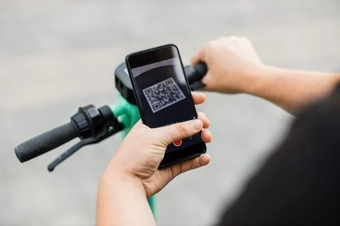 Man scan QR code by smart phone to unlock and rent electric push scooter on Foto stock