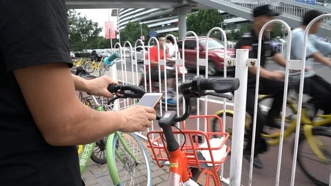 A man scaning the QR code of a Mobike's shared bike Stock Footage 93699710