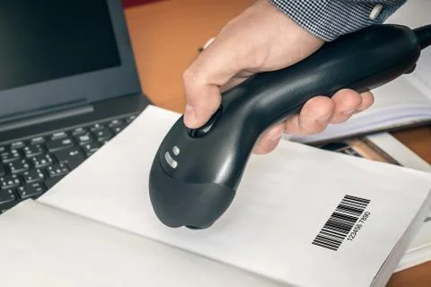 Man with scanner scans barcode in a book Stock-Fotos