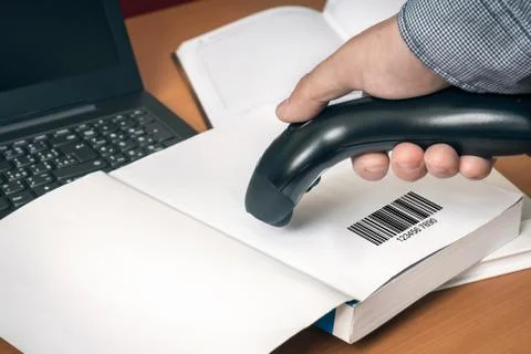 Man with scanner scans barcode in a book Stock-Fotos