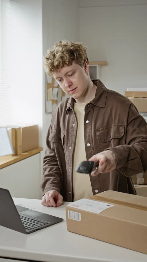Man Scanning Barcode on Cardboard Box and Typing on Laptop Stock Footage 342600529