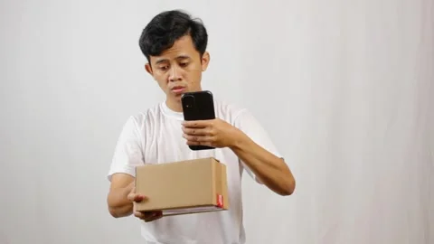 Man scanning barcode of package with smartphone Stock Footage 318757255