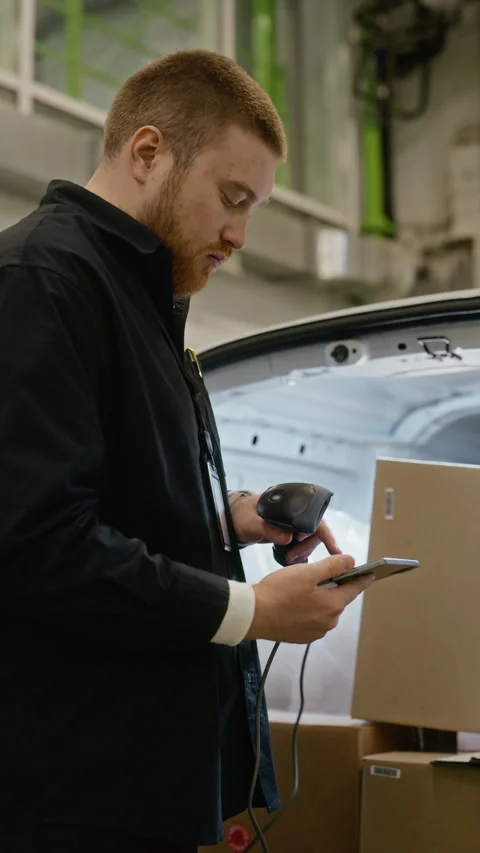 Man Scanning Cardboard Box with Barcode Scanner in Storage Stock Footage 340290475