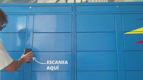 Man scanning a code on the mobile phone to pick up a package from a blue locker. Stock Footage 251757829