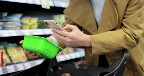 Man scanning product bar code in the shop using mobile phone app. Digital Video stock 189802754