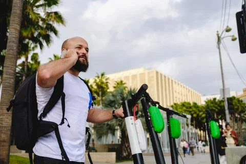 Man scanning qr code with his phone for electric scooter renting. Stock Photos