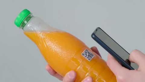A man scanning a QR code on juice bottle, close-up Stock Footage 169220923