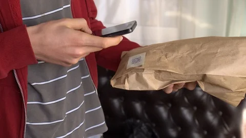 A man scanning a QR code on Product Packaging Stock Footage 104297305