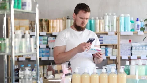 Man scans code on package of pills to check the expiration date Stockbeeldmateriaal 346646423