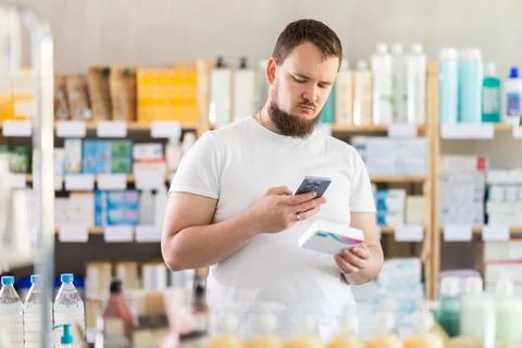Man scans code on package of pills to check expiration date Foto stock