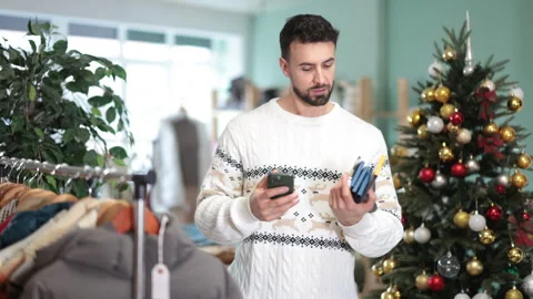 Man scans QR code and label of socks, X mas shopping Stock Footage 331315240