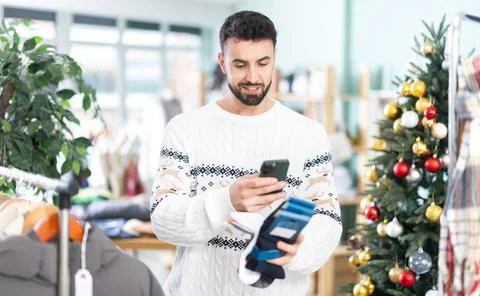 Man scans QR code and label of socks, X mas shopping Stock-Fotos