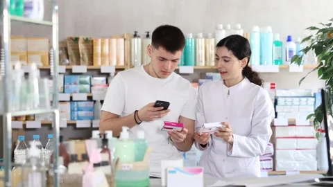 Man scans QR code on box paracetamol label. Female pharmacist offers to choose Video stock 325029262