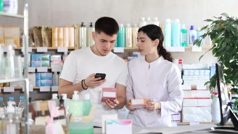 Man scans QR code on box pills label. Female pharmacist offers to choose the Stock Footage 328137154