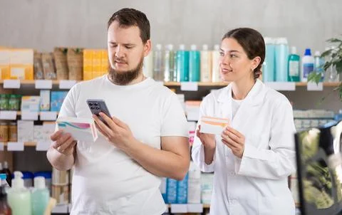 Man scans QR code on box pills label. Female pharmacist offers to choose right Stock Photos