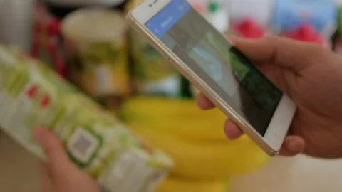 A man scans the QR code on a check on a juice box from a supermarket. 스톡 동영상 95730961