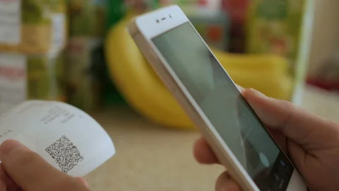 A man scans the QR code on a check from a supermarket. 스톡 동영상 95730972