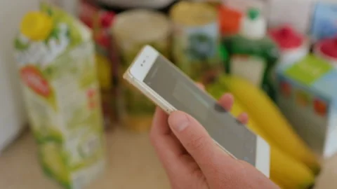 A man scans the QR code on a check on a juice box from a supermarket. 스톡 동영상 100724921