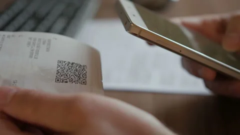 A man scans the QR code on a check from a supermarket. 스톡 동영상 100844221