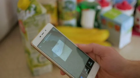 A man scans the QR code on a check on a juice box from a supermarket. 스톡 동영상 105848048